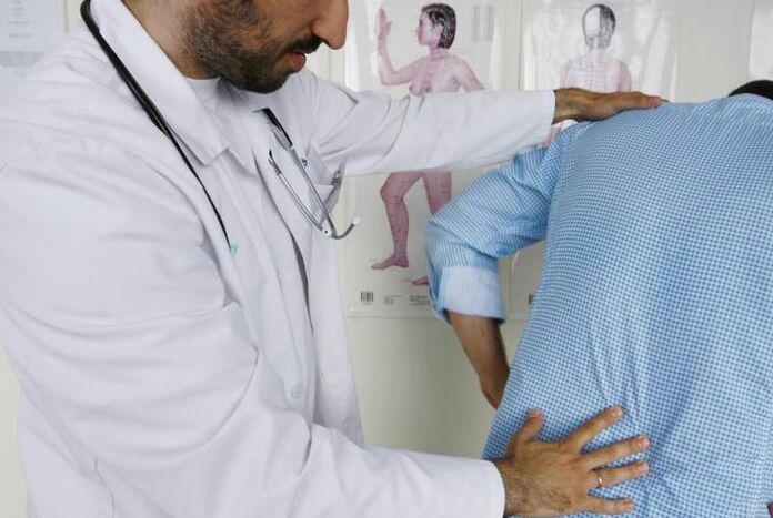 Médico examina a un paciente con dolor de espalda en la región lumbar