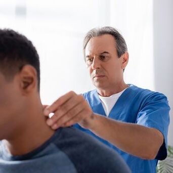 Un médico realiza un examen de diagnóstico a un paciente con dolor de cuello.